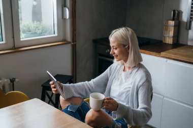 Young woman checks her mail on tablet