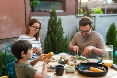 Caucasian family enjoys lunch in their backyard