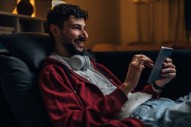 Caucasian man is using hid tablet in the evening