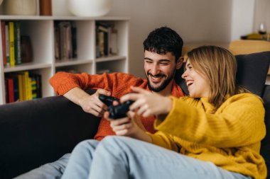 Güzel genç çift eğlenceli video oyunları oynuyor.