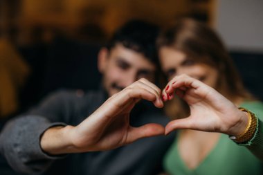 Genç bir çiftin ellerinden yapılmış bir kalp.