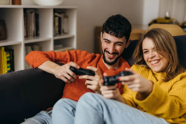 Young couple plays video games at home