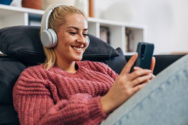 Blonde woman with headphones is having a video call