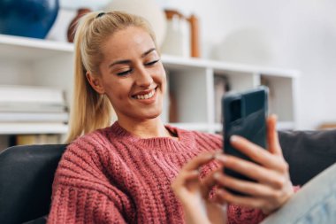 Young caucasian woman is using her mobile phone