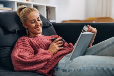 Blonde woman enjoys a book at home