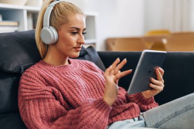 Blonde woman at home using tablet
