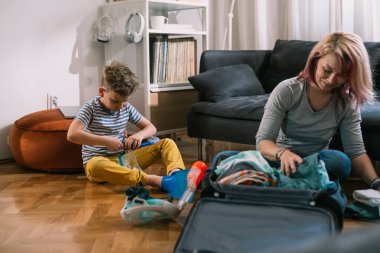 Mother and son are packing for a summer vacation