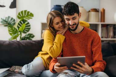 Happy young couple is surfing on the internet