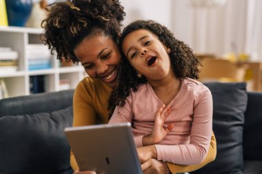 Woman and her daughter messing around while having a video call