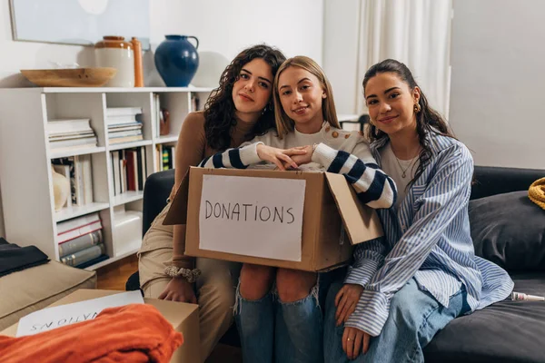 Three beautiful young women are donating clothes
