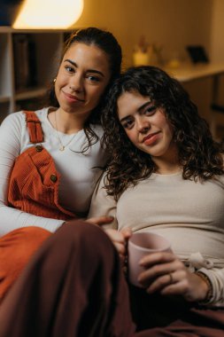 Two close female friends looking at the camera
