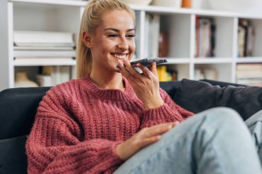Blond woman is having a phone call on speakerphone