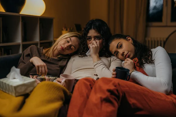 Three close friends watch a sad movie