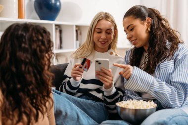 Friends use a credit card to shop online