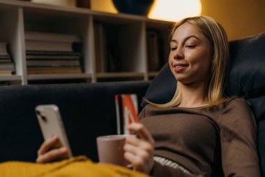 Woman is resting on the sofa and shopping online