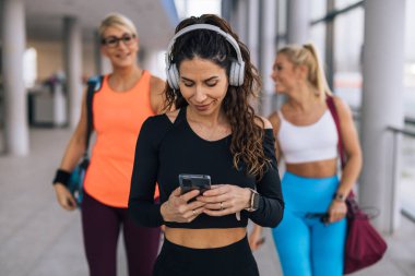 Front view of an attractive Caucasian woman in sportswear listening to music