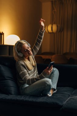 Happy Caucasian woman listens to her favorite song