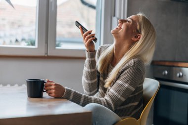 A beautiful woman is having a hilarious conversation over the phone