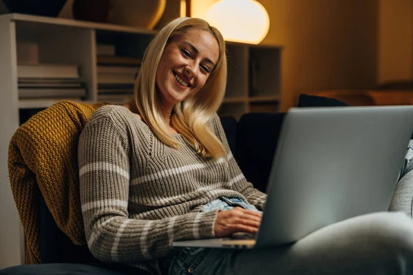 Happy Caucasian woman works on laptop at home