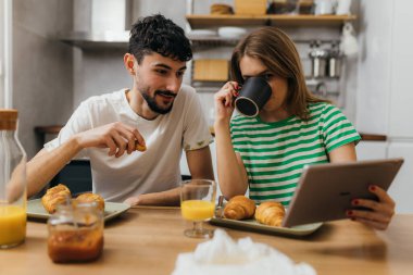 Portrait of a young caucasian couple having breakfast at home