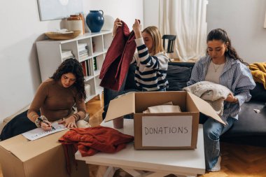 Women are folding clothes for donation