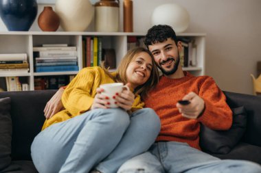 Cute young couple watches television