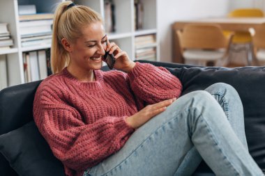 Blond Caucasian woman is having an enjoyable phone call