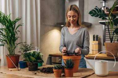 Florist is filling a flowerpot with dirt