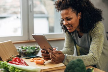 Happy woman looks at a recipe in the kitchen