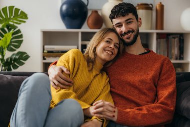 Genç beyaz çift evde sarılıp yatıyor.