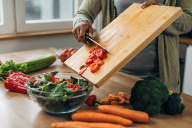 Kadın mutfakta besleyici sebze salatası yapıyor.