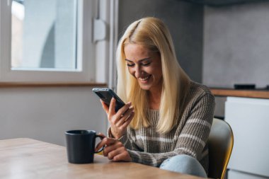 Kadın telefonla konuşurken gülüyor.