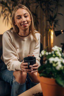 Genç bir kadın evinde bir polisle rahatlıyor.