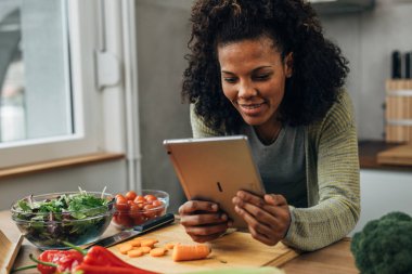 Güzel bir kadın mutfakta vegan tarifi hazırlıyor.