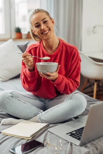 stock image A Caucasian college student eats breakfast on bed