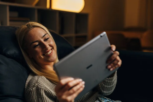 快乐的金发女人在家里用平板电脑 — 图库照片