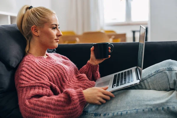 一个白人妇女在家上网工作的侧视图 — 图库照片