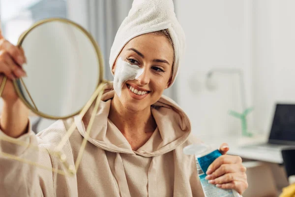Leende Kvinna Ser Sig Spegeln För Att Applicera Sin Ansiktsmask — Stockfoto
