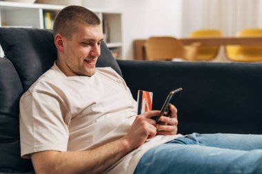 Adamın biri internetten kredi kartıyla alışveriş yapıyor.