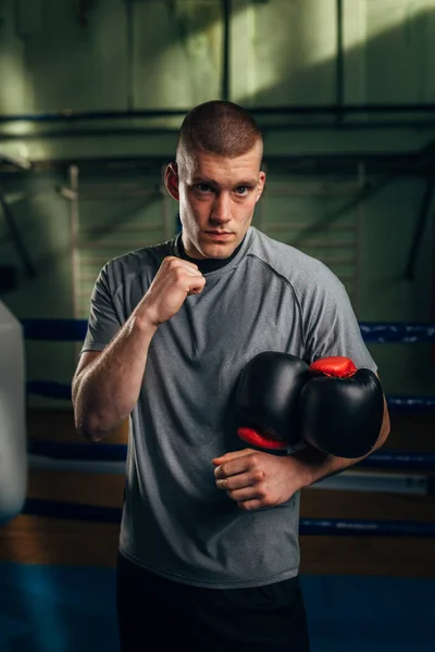 stock image Portrait of a Caucasian man fighter looking at the camera with his fist up and holding gloves