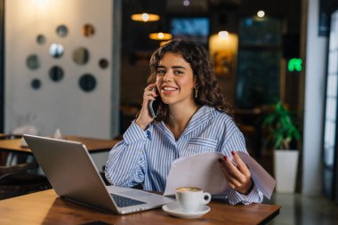 Güzel bir iş kadını telefon görüşmesi yapıyor.