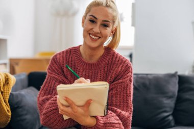 Bir kız öğrenci online dersi takip ediyor.