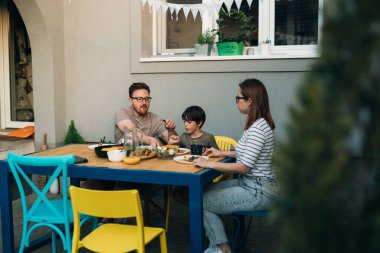 Beyaz bir aile hafta sonu arka bahçede güzel bir yemek yiyor.