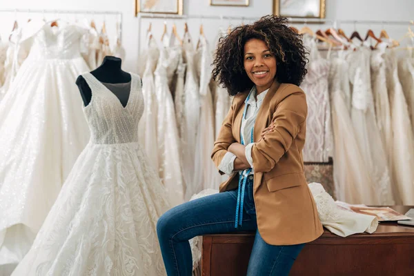 A happy woman works in a bridal shop as a tailor