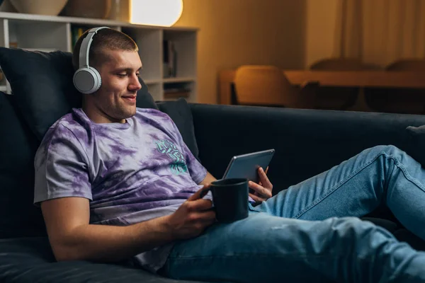 Yakışıklı Bir Adam Tek Başına Oturma Odasında Oturuyor Akşamları Tablet — Stok fotoğraf