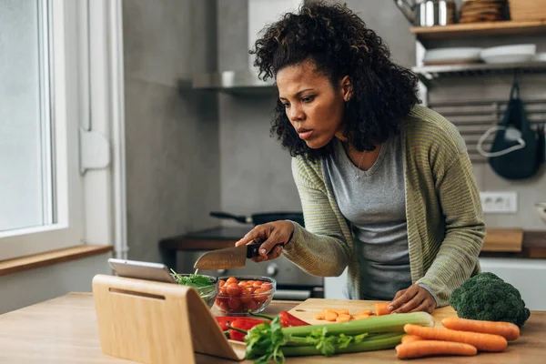 stock image A woman is following a healthy recipe on tablet