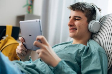 Genç bir çocuk boş zamanlarında tablet kullanmaktan hoşlanır.