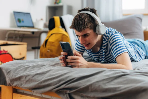 Кавказький Підліток Користується Мобільним Телефоном Коли Лежить Ліжку — стокове фото