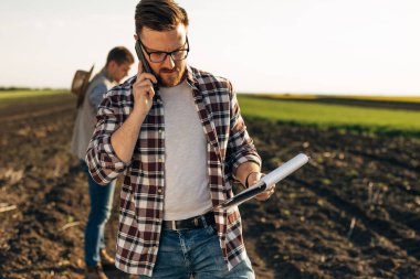 Tarlada bir adam telefon görüşmesi yapıyor..