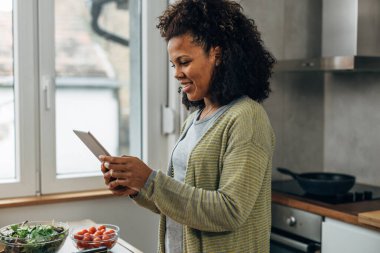 Mutfakta dikilip dijital tablet kullanmak mutluluktur..